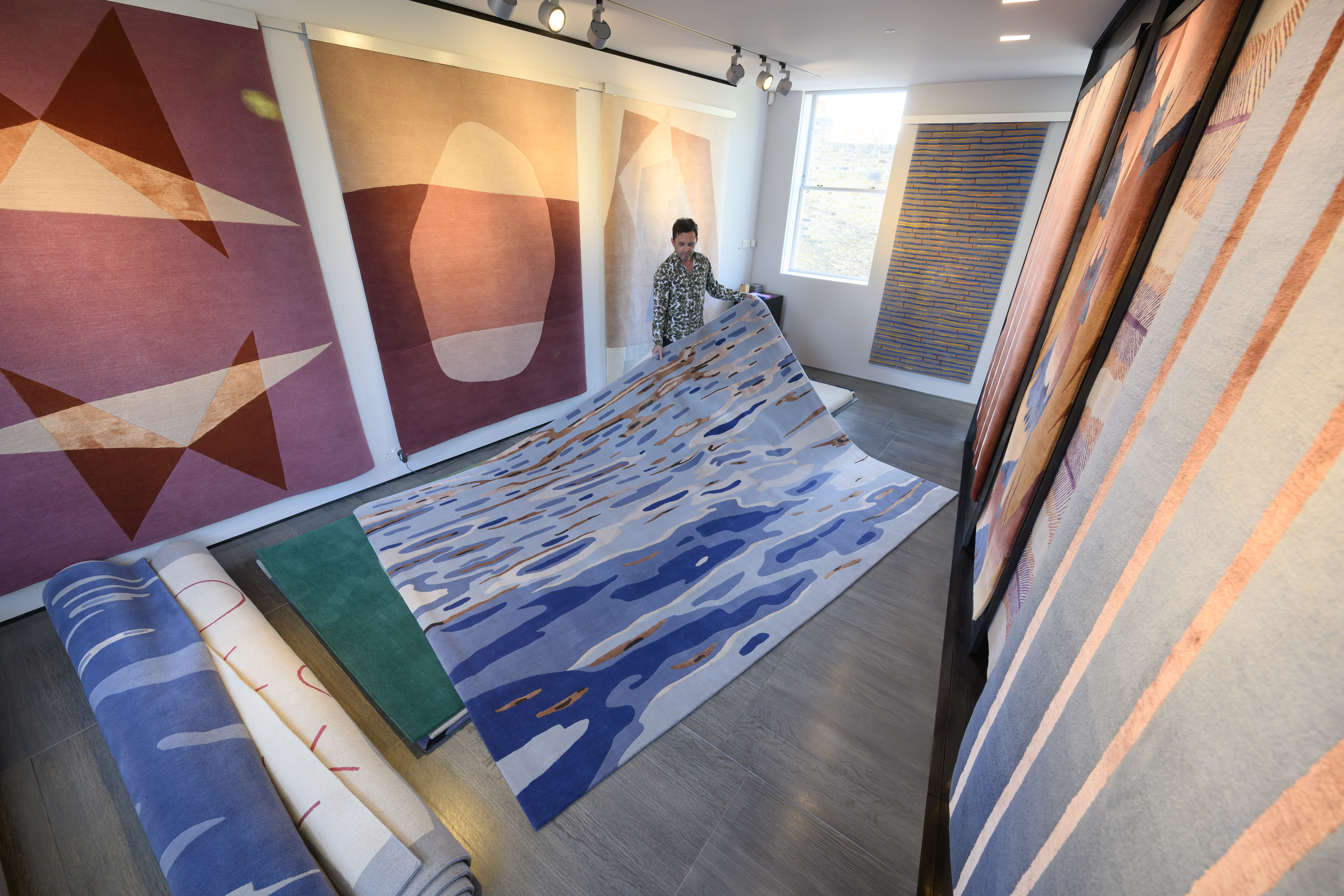Trade Sales Manager Chris Kane showcasing some of Deirdre Dyson's custom rug designs