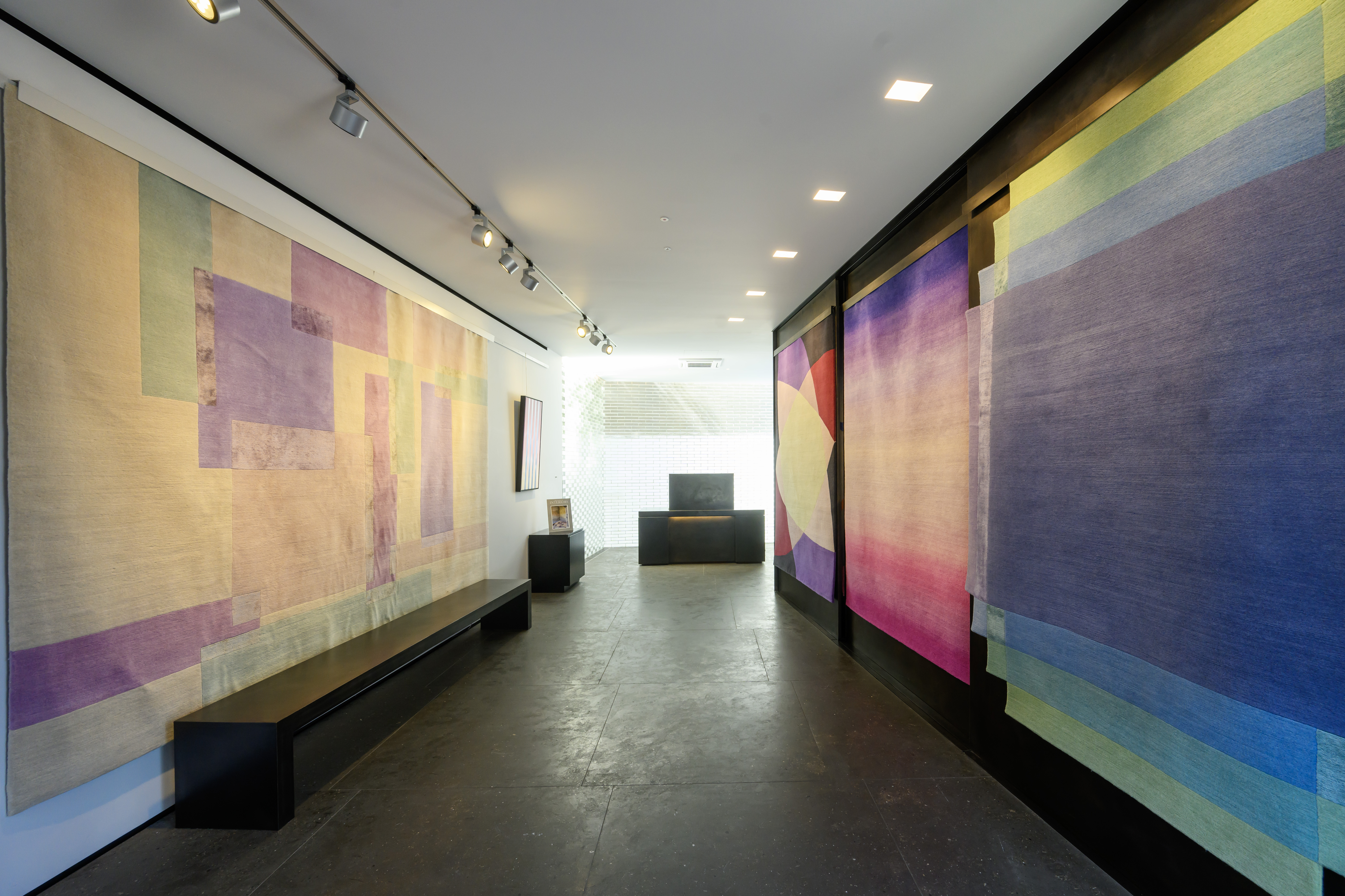 The interior of Deirdre Dyson's carpet gallery at 554 Kings Road, London featuring a selection of her bespoke hand knotted rug designs