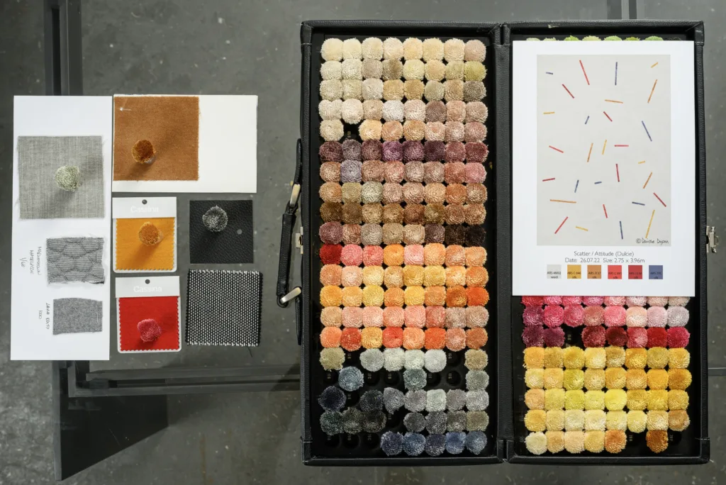 A custom version of Deirdre Dyson's ATTITUDE carpet with wool and silk poms